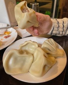 a person is eating dumplings on a plate