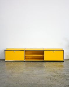 a yellow entertainment unit with two doors and shelves