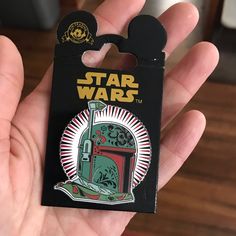 someone holding up a star wars pin in their hand