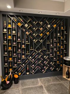 a wine rack with many bottles on it in the middle of a room next to a wall