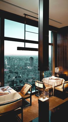 a dining room with a view of the city from it's high rise window