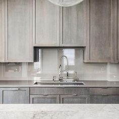 a kitchen with gray cabinets and white marble counter tops is featured in the ad for an appliance company