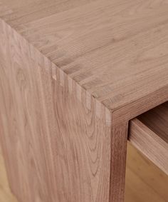 a close up view of a wooden table with one drawer open and the other closed