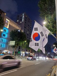 a car driving down the street with a flag hanging from it's side