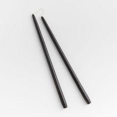 two black chopsticks sitting next to each other