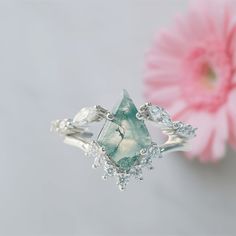 a close up of a ring with a flower in the background