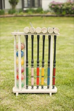 an old croquet rack with balls and bats in it on the grass outside