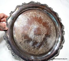 a person is holding an ornate silver plate