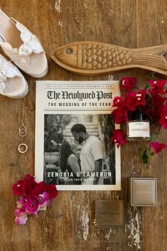 the bride's shoes, ring box, and magazine are laid out on a wooden table