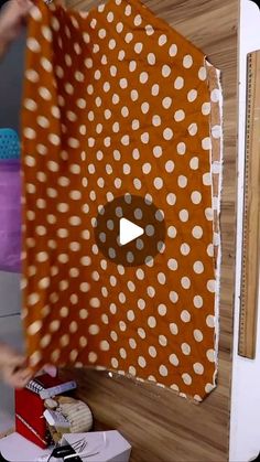 a person holding up a piece of fabric with polka dots on it and the video below