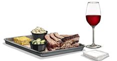 a glass of wine and some food on a tray