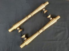 three brass telescopes sitting on top of a black cloth