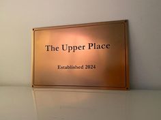 the upper place sign is mounted on the wall