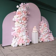 there are many flowers on the wall and one is pink, white and grey in color