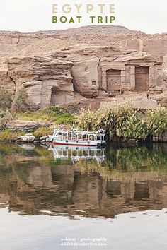 a boat floating on top of a body of water next to a rocky cliff face