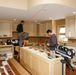 two men are standing in the middle of a large kitchen with lots of counter space