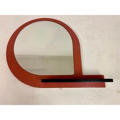 the mirror is shaped like an arch and has a black strip on one side, and a red band on the other