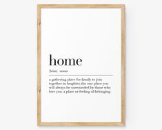 a framed poster with the words home in black and white, on top of a wall