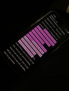 a close up of a cell phone with pink text on the screen and black background