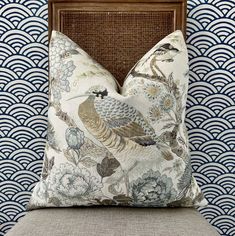 a bird pillow sitting on top of a chair in front of a blue and white wall