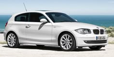 a white car parked on top of a sandy beach