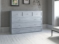 an empty room with a gray dresser and pictures hanging on the wall, along with a white chair