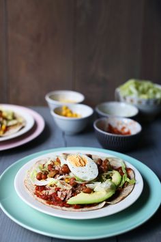 a table topped with plates filled with tacos and other food on top of it