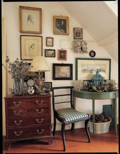 a room with many pictures on the wall and an old chair in front of it