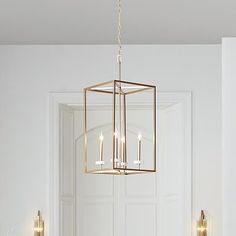 a chandelier hanging from the ceiling in a room with white walls and flooring