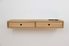 a wooden shelf with two drawers on it and a pen sticking out of the drawer