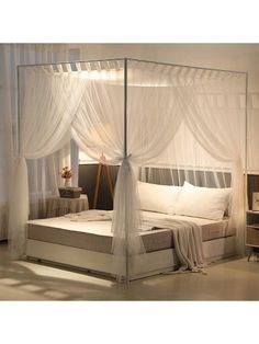 a white bed with sheer curtains over it