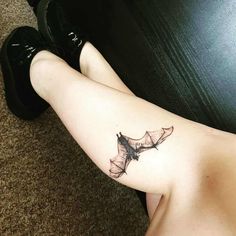 a woman's leg with a small tattoo on her left arm and the bottom part of her legs