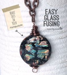 a necklace with a glass bead hanging from it's side on a chain