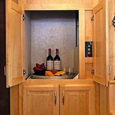 two bottles of wine are sitting in the corner of a cabinet that is built into the wall