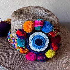 This Key West Collection Is To Showcase Our Beautiful Handmade Straw Hats Made In Mexico All Of The Decorations Are Done By Hand . This Beautiful Handmade Summer Hat Has Vibrant Colored Pom Poms, Crochet Evil Eye And Woven Colorful Band. Each Hat Is A One-Of-A-Kind Piece Of Artwork, Rim: 4 Inches Height: 5 Inches Evil Eye: Approx. 3 Inches Diameter The Band Is Approx. 2 Inches Thick. It Also Hast A Elastic Strap Inside For Comfort And Fit Woven Straw Panam Hat Style Crochet Band And Protective E Handmade Multicolor Sun Hat For Vacation, Multicolor Hats For Beach Season Travel, Multicolor Hats For Travel And Beach Season, Multicolor Hats For Travel During Beach Season, Handmade Blue Sun Hat For Vacation, Panama Hat Style, Crochet Evil Eye, Eclipse Party, Harry Potter Sorting Hat