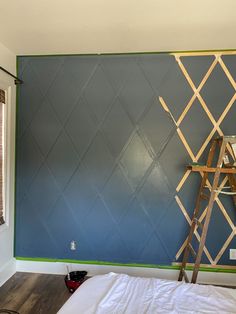 a room that has been painted with blue and green wallpaper, including a ladder