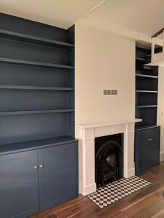 a living room with blue bookcases and a fireplace in the middle of it