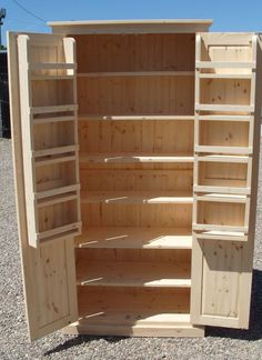 an open wooden cabinet sitting on top of gravel