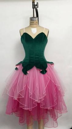 a mannequin wearing a green and pink dress