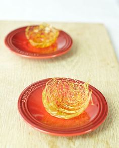 two red plates with yellow food on them