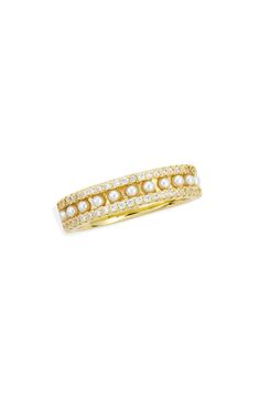 a yellow gold ring with pearls and diamonds on the outside, set against a white background