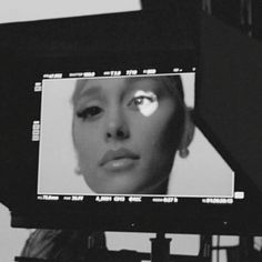 a black and white photo of a woman's face on a television monitor screen