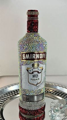 a bottle of smirnoff on a silver tray with some diamonds around it