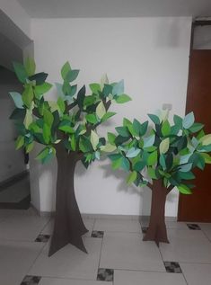 two paper trees sitting on top of a tiled floor