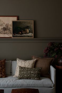 a living room with couches and pictures on the wall