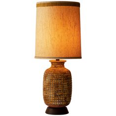 a lamp that is on top of a wooden base with a light shade over it