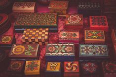 many different colored boxes are on the table with red and yellow designs around them,