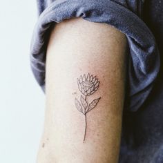 a small flower tattoo on the arm