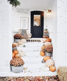 pumpkins and gourds decorate the front porch for fall