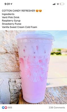 a pink starbucks cup sitting on top of a wooden table